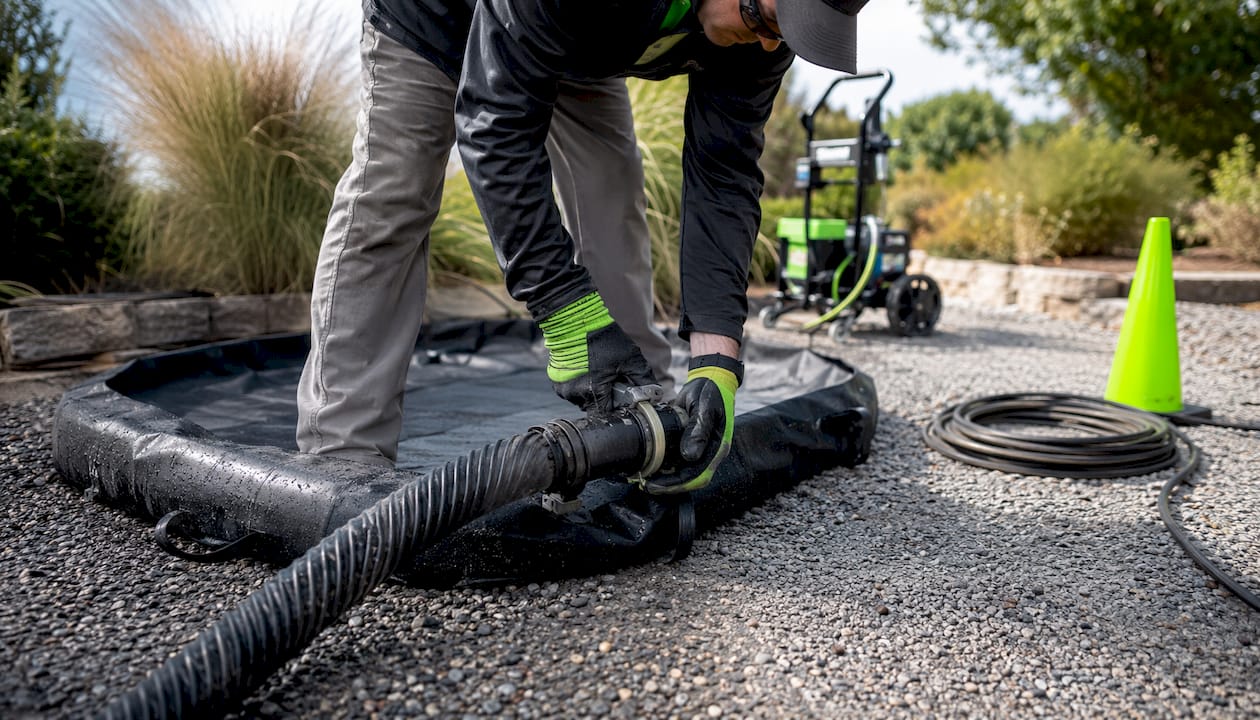 Hands connecting hose to water containment unit