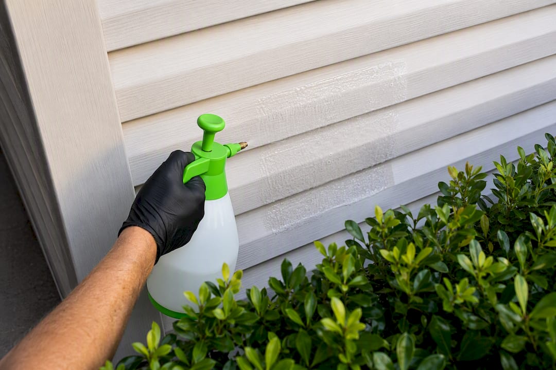 Technician testing cleaner on hidden siding