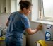 Woman cleaning bathroom mildew with sponge
