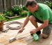 Homeowner gently cleans wooden deck outdoors