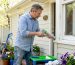 Homeowner applying sealant on window frame outdoors