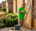 Homeowner cleaning downspout ladder outside