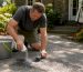 Homeowner applying absorbent to oil stain