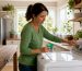 Woman selecting water temperature on washing machine