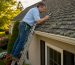 Homeowner inspecting lichen on roof shingles