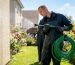 Technician performing low-pressure rinsing on house exterior