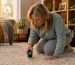 Woman measuring floor dryness with moisture meter