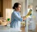 Woman cleaning grimy window in living room