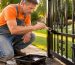 Homeowner painting exterior metal gate to prevent rust