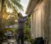 Man inspecting algae-covered Florida roof