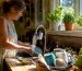 Woman rinsing dishes with filtered water at home kitchen sink