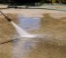Pressure washing nozzle spraying driveway outdoors