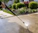Technician pressure washing concrete driveway