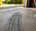 Rubber tire marks embedded in concrete driveway