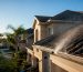 Technician soft washing Florida HOA home roof