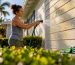 Homeowner rinsing pollen from textured siding